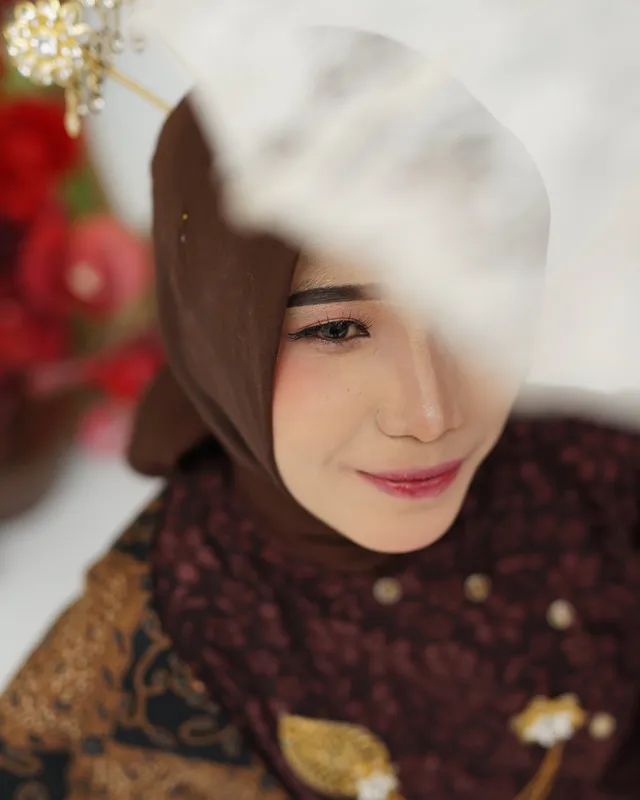 Close-up mempelai wanita tersenyum di antara bunga