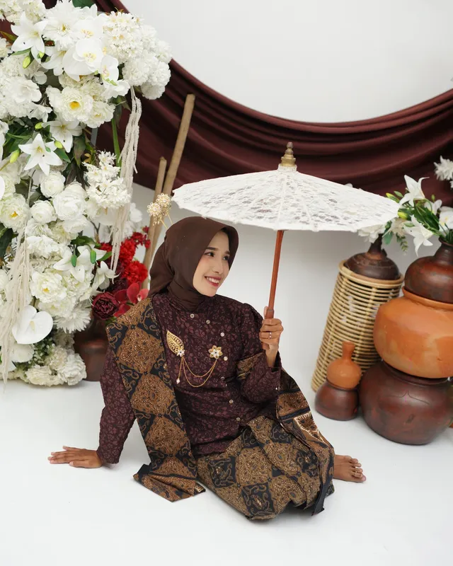 Mempelai wanita duduk bersimpuh dengan payung putih